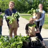 The SAP farm crew poses with the recently packed farm shares that are ready for delivery!